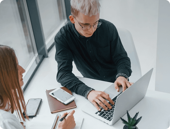 Two people working at a laptop